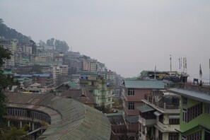 Uma área urbana densamente povoada com edifícios altos, alguns com varandas, e uma estrutura curva com cobertura metálica.