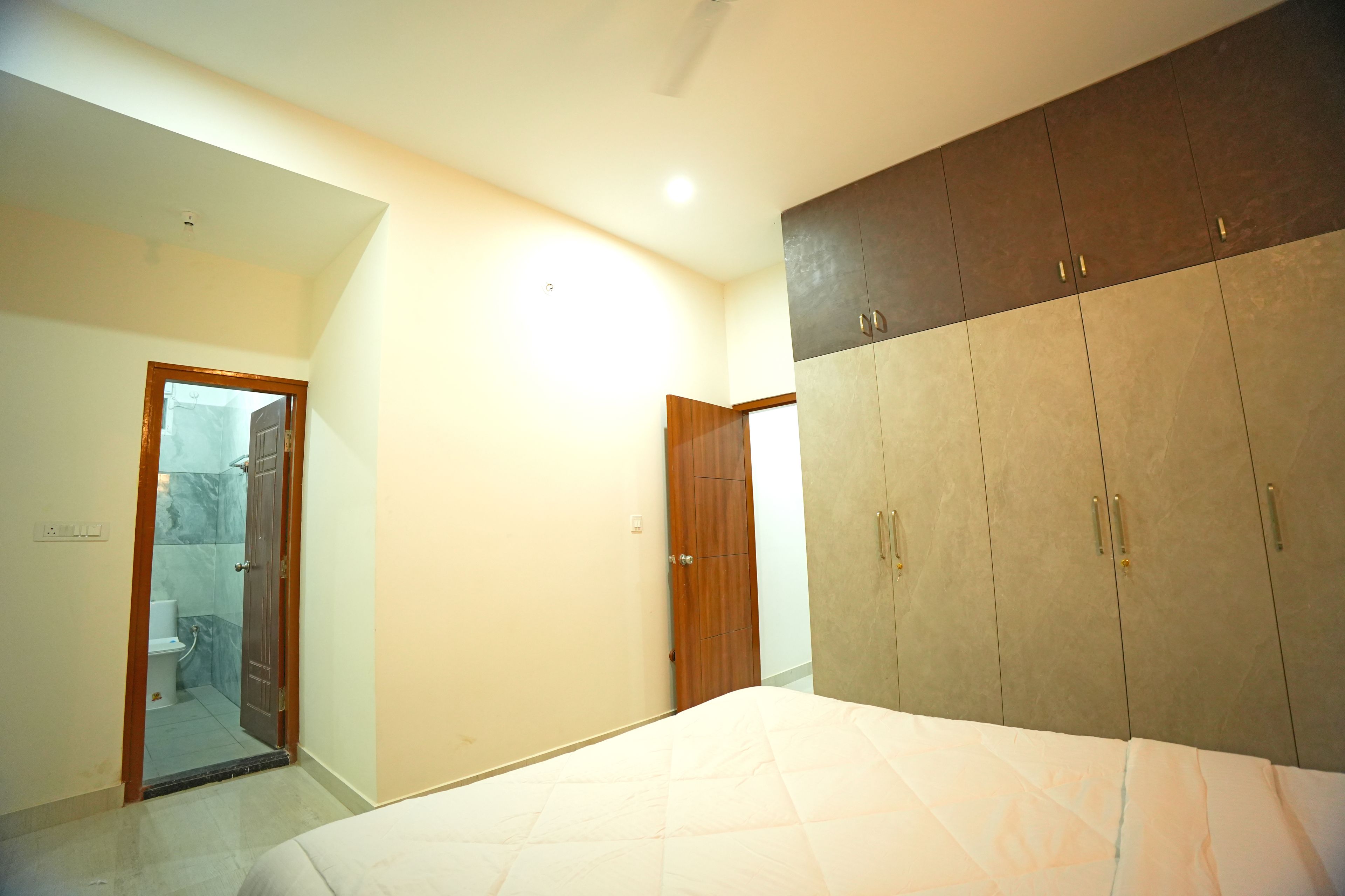 A bedroom with a bed, wardrobe, and a bathroom with a shower.