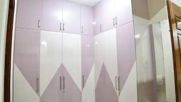 A room with a large wardrobe, a mirror, and a wooden door.