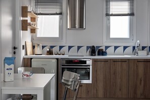 A modern kitchen with a built-in oven, a coffee machine, and a milk carton on the counter. - Modern 2BD Apartment near Acropolis by Lumen Living (Athina)