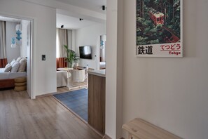 Un salon moderne avec un canapé, un téléviseur et un coin repas comprenant une table et des chaises.