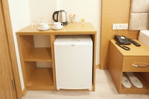 A compact kitchenette with a refrigerator, a coffee maker, and a cup. - Kartal Palace Taksim Square FAMILY HOTEL (Istanbul)