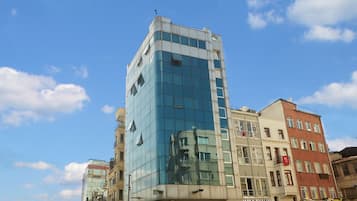 Un immeuble à plusieurs étages doté d’une façade en verre et de plusieurs boutiques situées au rez-de-chaussée.