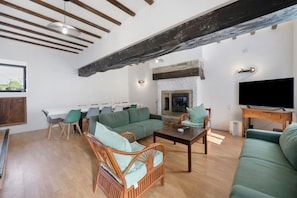 A spacious living area with a fireplace, seating, and a television.