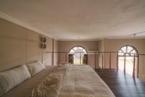 A bedroom with a large bed, a window with a decorative arch, and a view of the outside. - Toffee Homestay Ninh Binh (Hoa Lu)