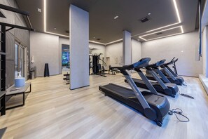 A modern gym with treadmills, exercise equipment, and a wooden floor. - Valen by Bhomy (São Paulo)