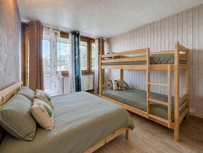 A room with bunk beds, a single bed, and a window with curtains. - Apartment at the slopes - 8 guests (La Plagne)