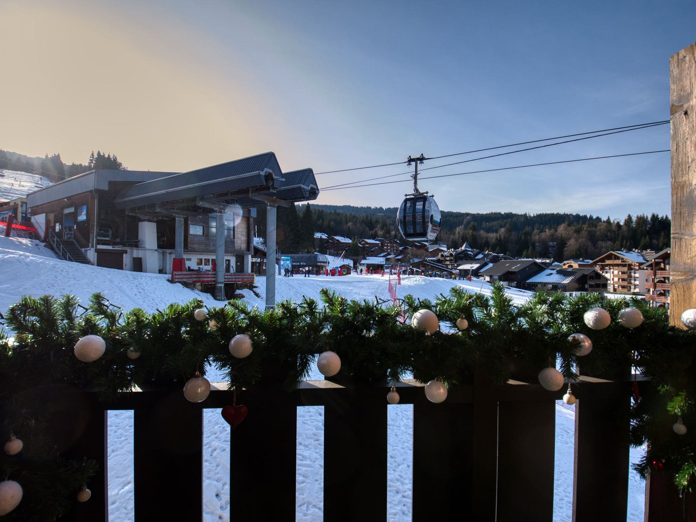 A ski resort with a lift station, buildings, and a snowy landscape.