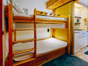 A bunk bed room with a kitchen area. - Cosy studio in the center of Arc 1800, Ideal for 3 people (Les Arcs 1800)