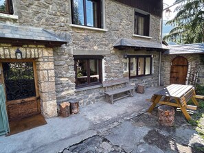 A stone building with multiple windows, a wooden bench, and a table set up outside. - Spacious apartment - 12 guests (Valloire)