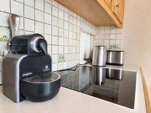 A kitchen with a Magimix Nespresso coffee machine, stainless steel pots, and a tiled backsplash. - Cozy apartment, mountain view (Méribel)