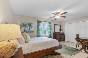 A bedroom with a bed, a ceiling fan, a window with curtains, a dresser, and a mirror. - La Tortuga! Gulf Access Pool, Spa, Dock & Tiki hut on canal. Close to beaches (Cape Coral)