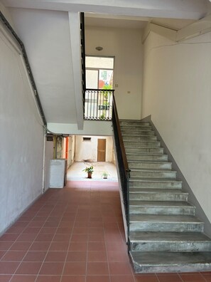 A staircase leading to an upper floor with a view of the street below. - Room 'Camera Clio' with Balcony, Wi-Fi and Air Conditioning (Siracusa)