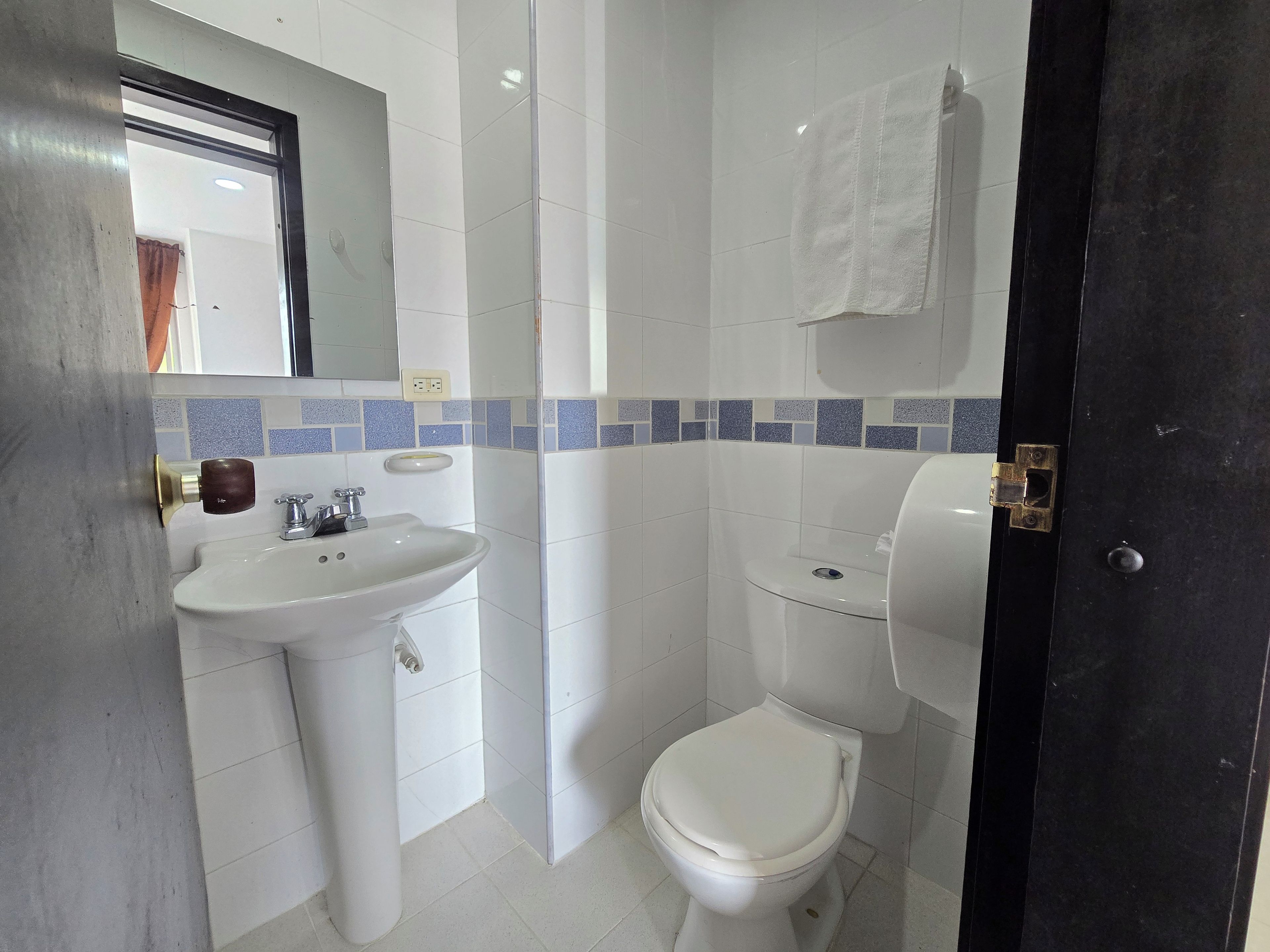 Un bagno con un lavandino bianco, un water e uno specchio.