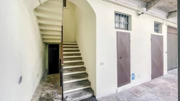 Un escalier menant à une porte, un luminaire fixé au mur et une porte dotée d’une fenêtre.