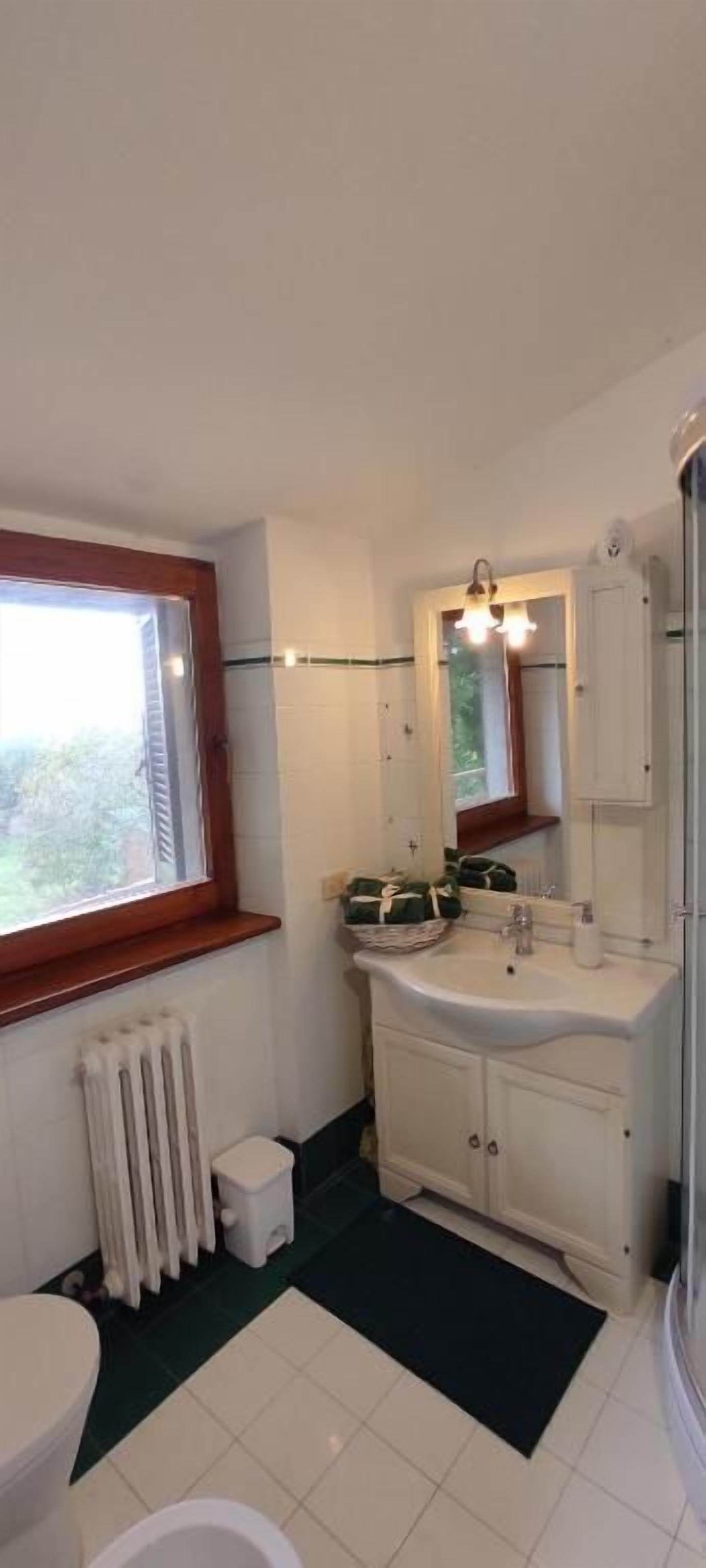 Et badeværelse med toilet, vask og vindue.