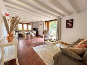 A living room with a sofa, a coffee table, and a dining area with chairs and a table. - La Parenthèse Suryssoise: Sit down, take a breath... Near Sancerre and the Loire River (Sury-ès-Bois)