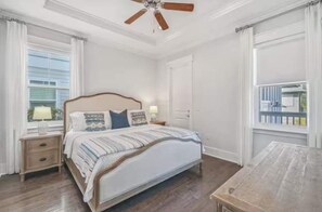 A bedroom with a bed, nightstands, a ceiling fan, and a window with curtains. - NEW Seaglass Villa | Golf Cart + 5 Bikes | 30A (Santa Rosa Beach)