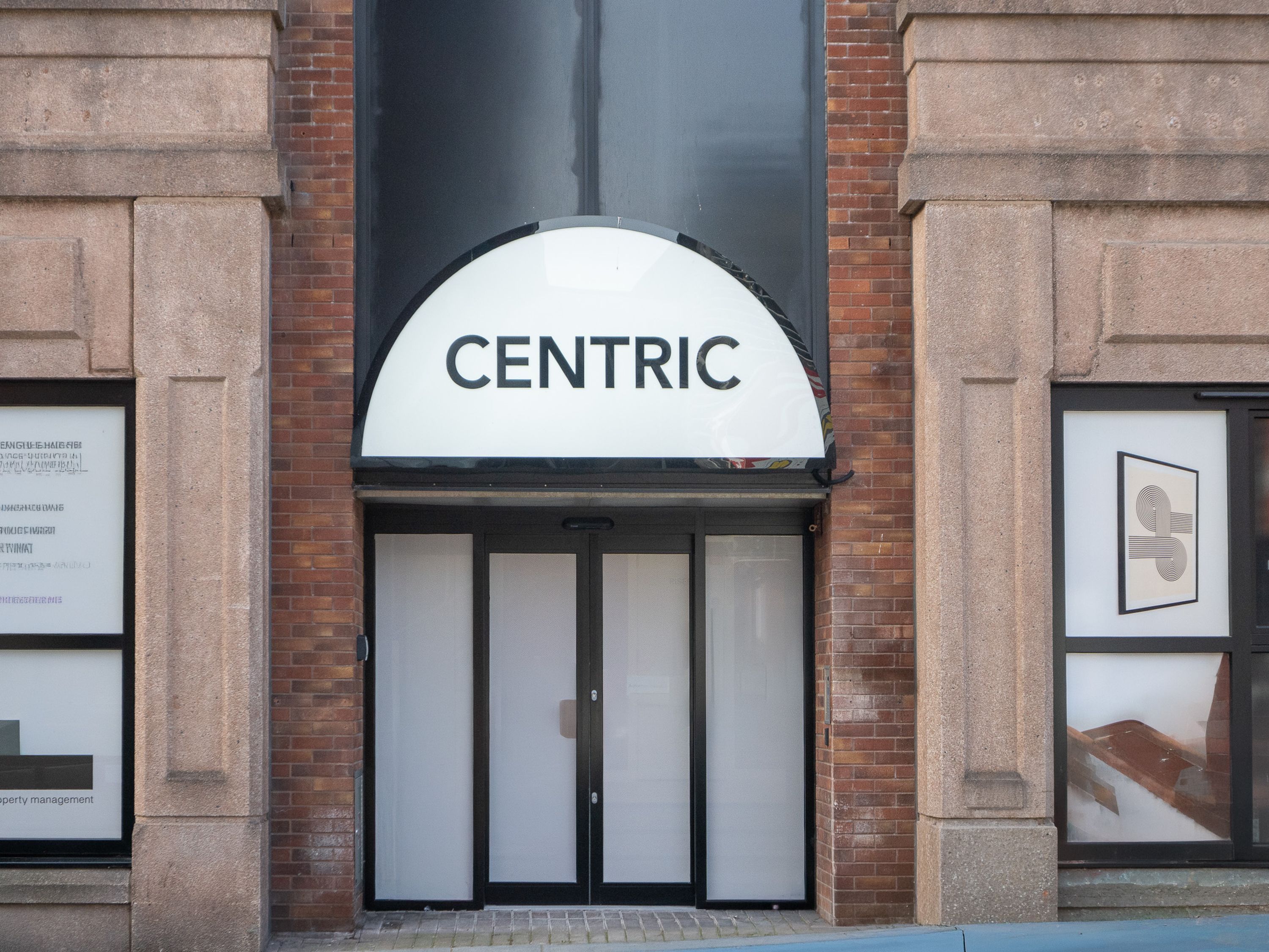 A building entrance with a sign reading 'CENTRIC' above the doors.
