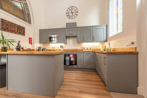 Une cuisine moderne avec des meubles gris, un îlot central et une grande fenêtre.