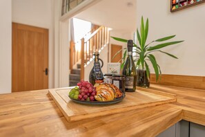 Un comptoir en bois avec une assiette de nourriture, une bouteille et une plante.
