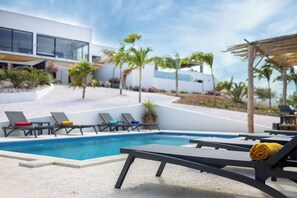 A modern poolside area with lounge chairs and a clear blue pool. - Casa Pasha - Apartment Sasha - Jan Thiel (Jan Thiel)