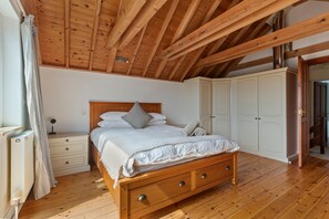 Ein Schlafzimmer mit einem hölzernen Bett, einem Nachttisch, einem Kleiderschrank und einer Heizung.