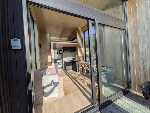 Een modern interieur met een keuken, een eetgedeelte en een glazen schuifdeur die leidt naar een buitenruimte.