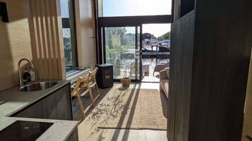 Een moderne keuken met een ingebouwde kookplaat, een spoelbak en een raam met uitzicht op een balkon.