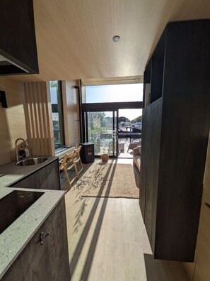 Een moderne keuken met een ingebouwde kookplaat, een spoelbak en een raam met uitzicht op een balkon.