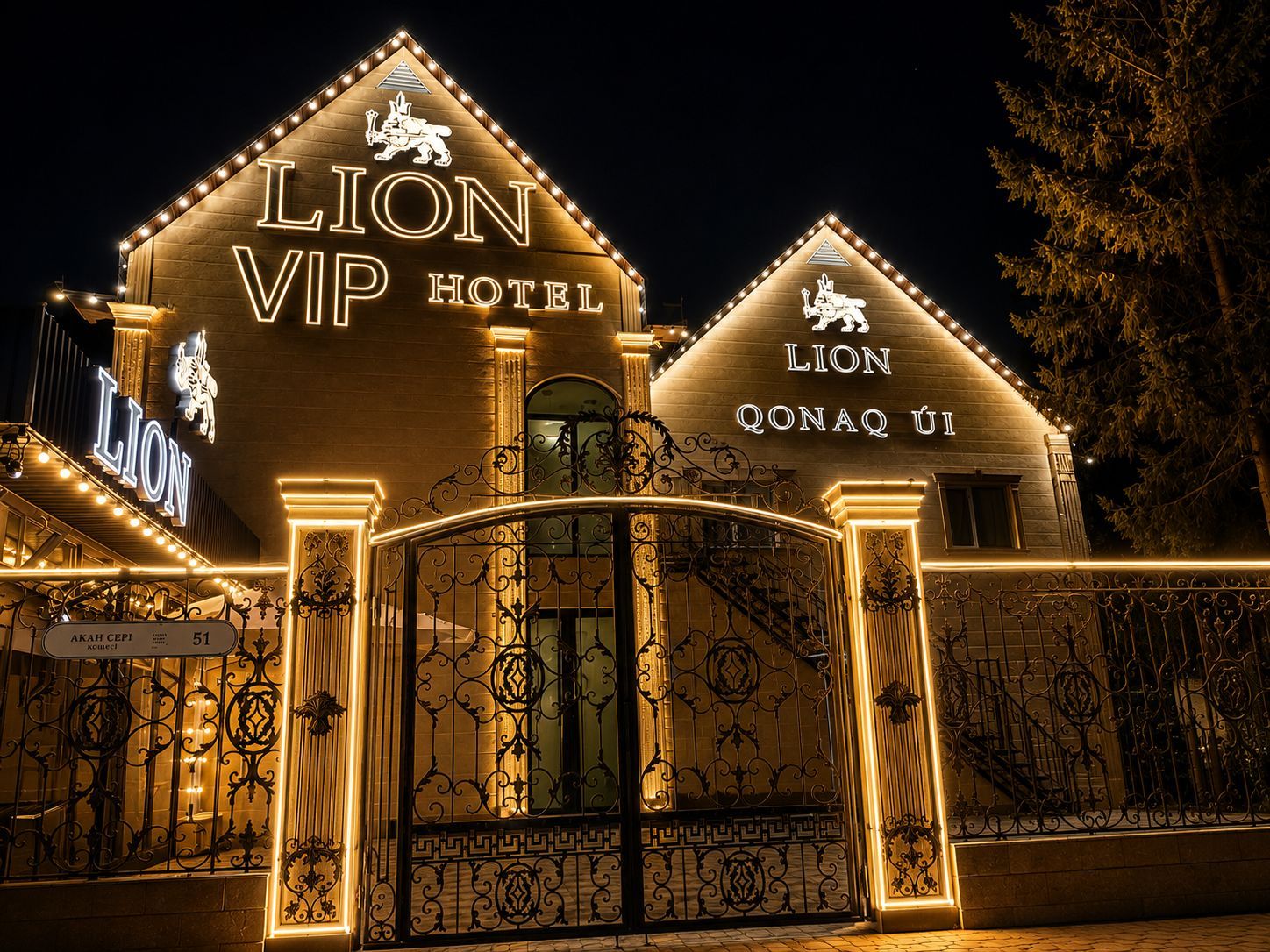The exterior of the Lion Vip Hotel with illuminated signage and ornate ironwork.