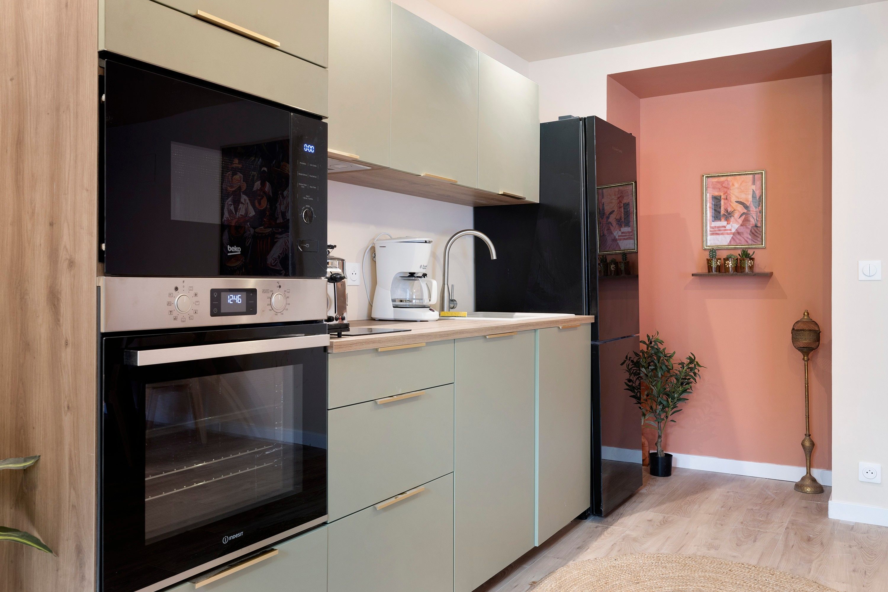 A modern kitchen with built-in appliances, a coffee maker, and a refrigerator.