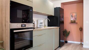 A modern kitchen with built-in appliances, a coffee maker, and a refrigerator.