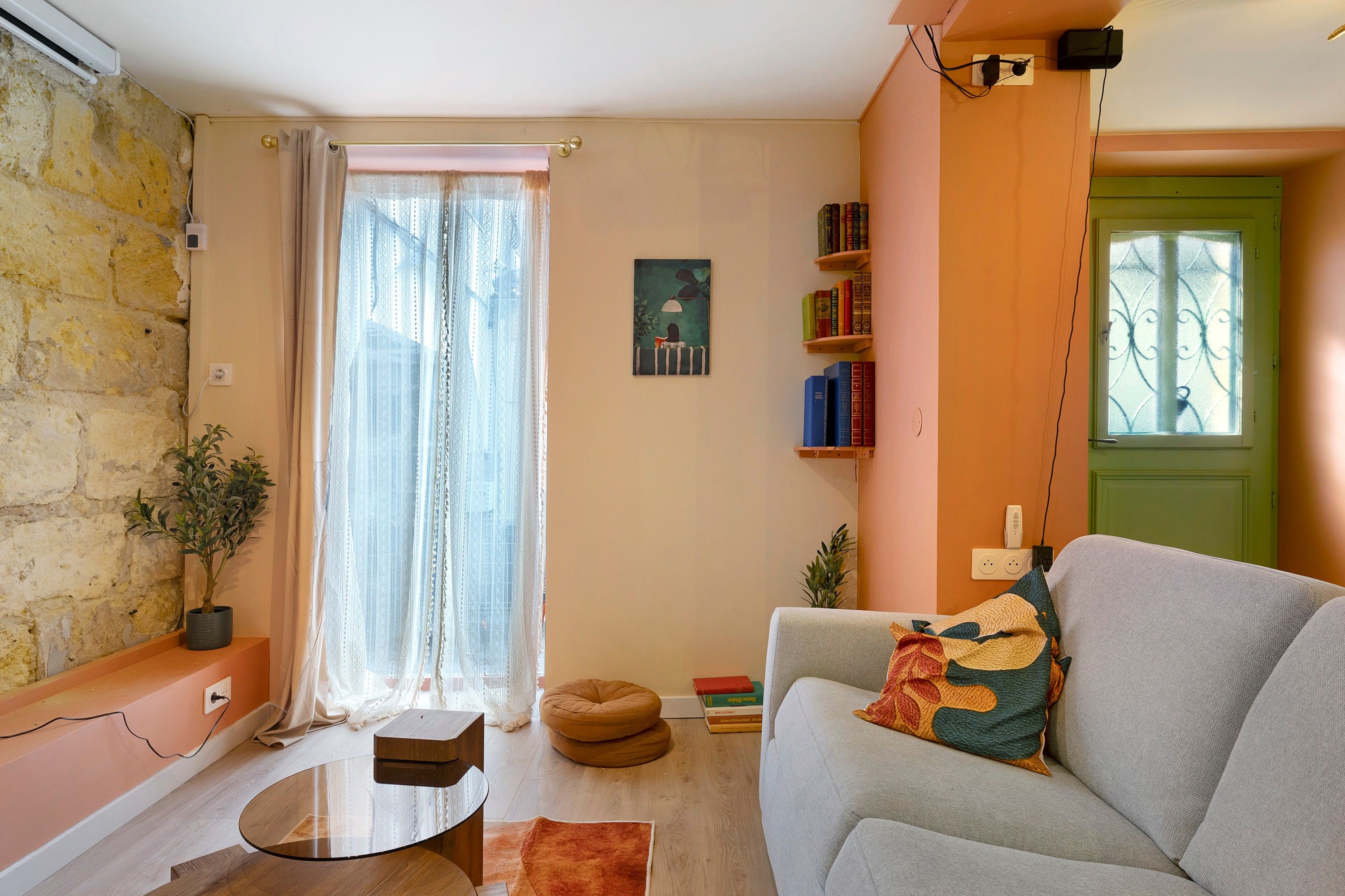 Ein Wohnzimmer mit einer Couch, einem Couchtisch, einem Blumentopf und einem Bücherregal.