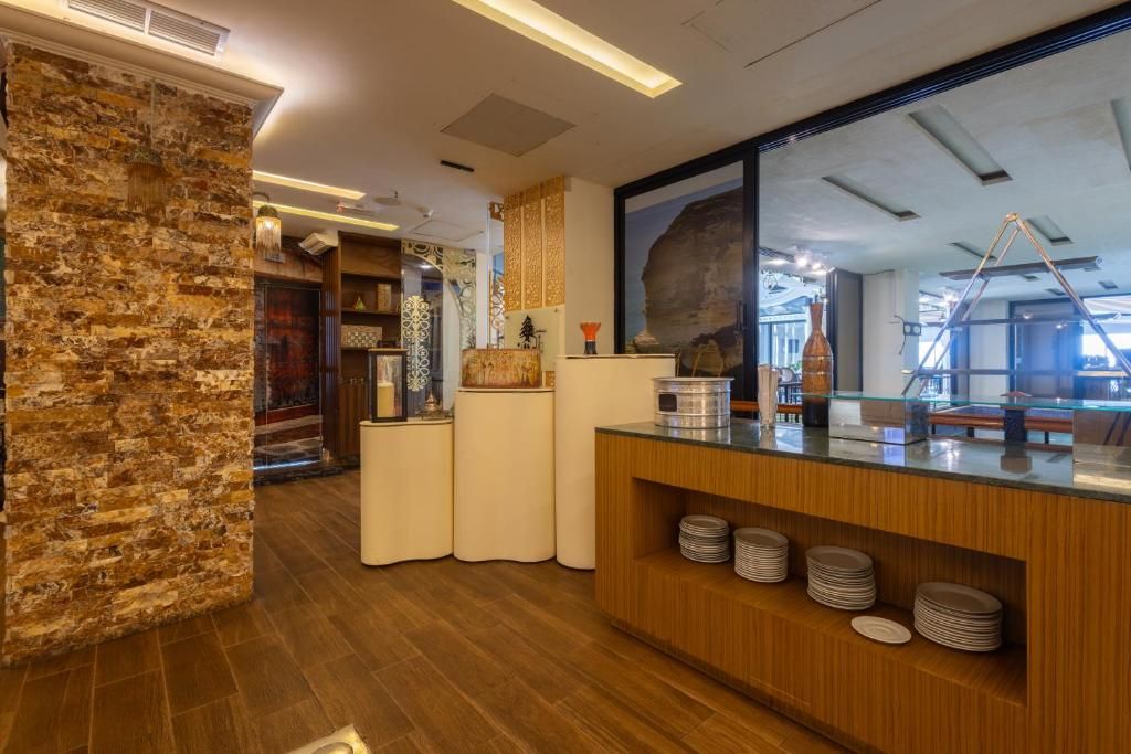 Una zona de recepción con pared de piedra, mostrador de madera y un ventanal grande.