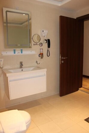 A bathroom with a sink, mirror, and toilet. - Dolphin Continental Hotel (SALMIYA)