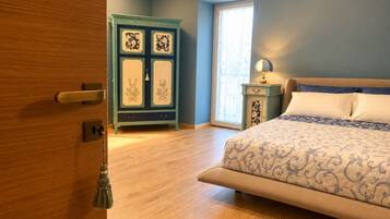 A bedroom with a bed, a wardrobe, a nightstand, and a window.