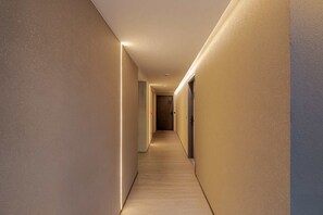 A hallway with a light-colored floor and walls, leading to a door marked with the number 283. - MOT Rentals + Design SohoHaus '305' - 3 pax Full Amenities (Buenos Aires)