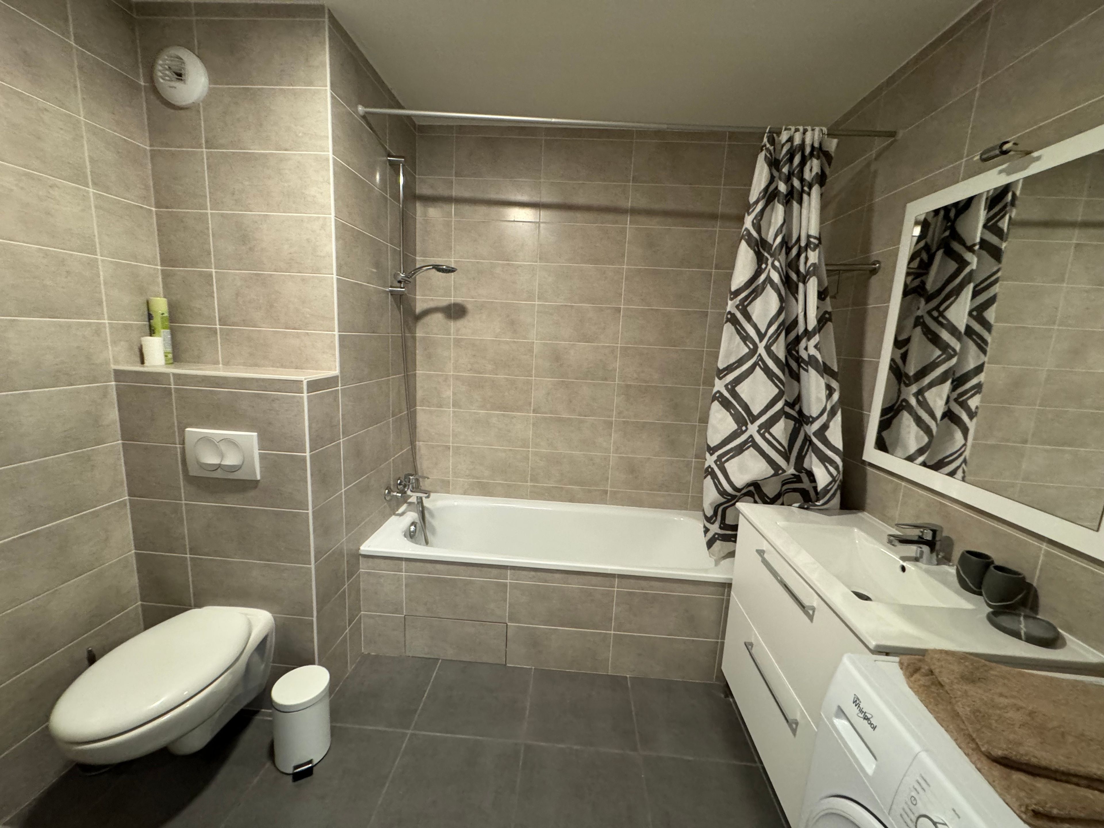 Ein modernes Badezimmer mit Badewanne, Toilette und Waschbecken mit Handtuch.