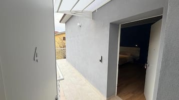 Un passadís amb una porta que dona a una habitació amb un llit i una finestra.