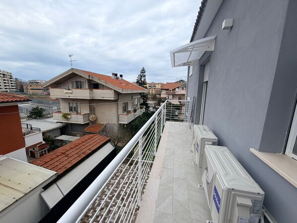 A residential building with a balcony, a satellite dish, and a view of neighboring houses. - Palazzo del toro 2 (Montesilvano)