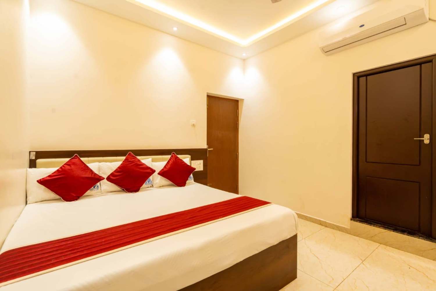 Quarto de hotel com cama, porta e unidade de ar condicionado.