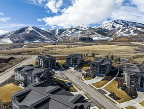Ein Wohnkomplex mit mehreren Gebäuden, einer zentralen Straße und einer Bergkulisse.