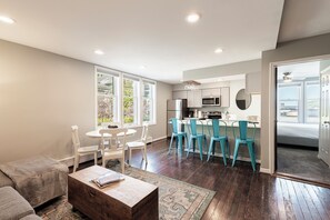 A modern living room with a sofa, coffee table, and a dining area with chairs. - Historic Old Town condo with 3 bedrooms, 3 baths, sleeps 10. (Park City)