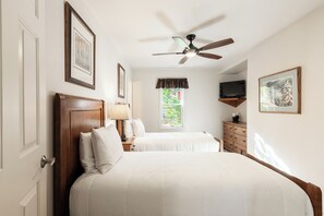 A hotel room with two beds, a ceiling fan, a TV, and framed artwork on the walls. - Historic Old Town 5BR/5BA stay in Park City. (Park City)