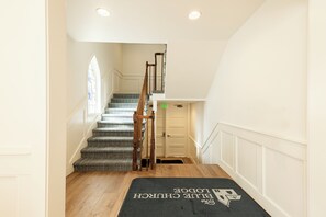 Una escalera con alfombra estampada que conduce a una puerta señalizada con 'EXIT'.