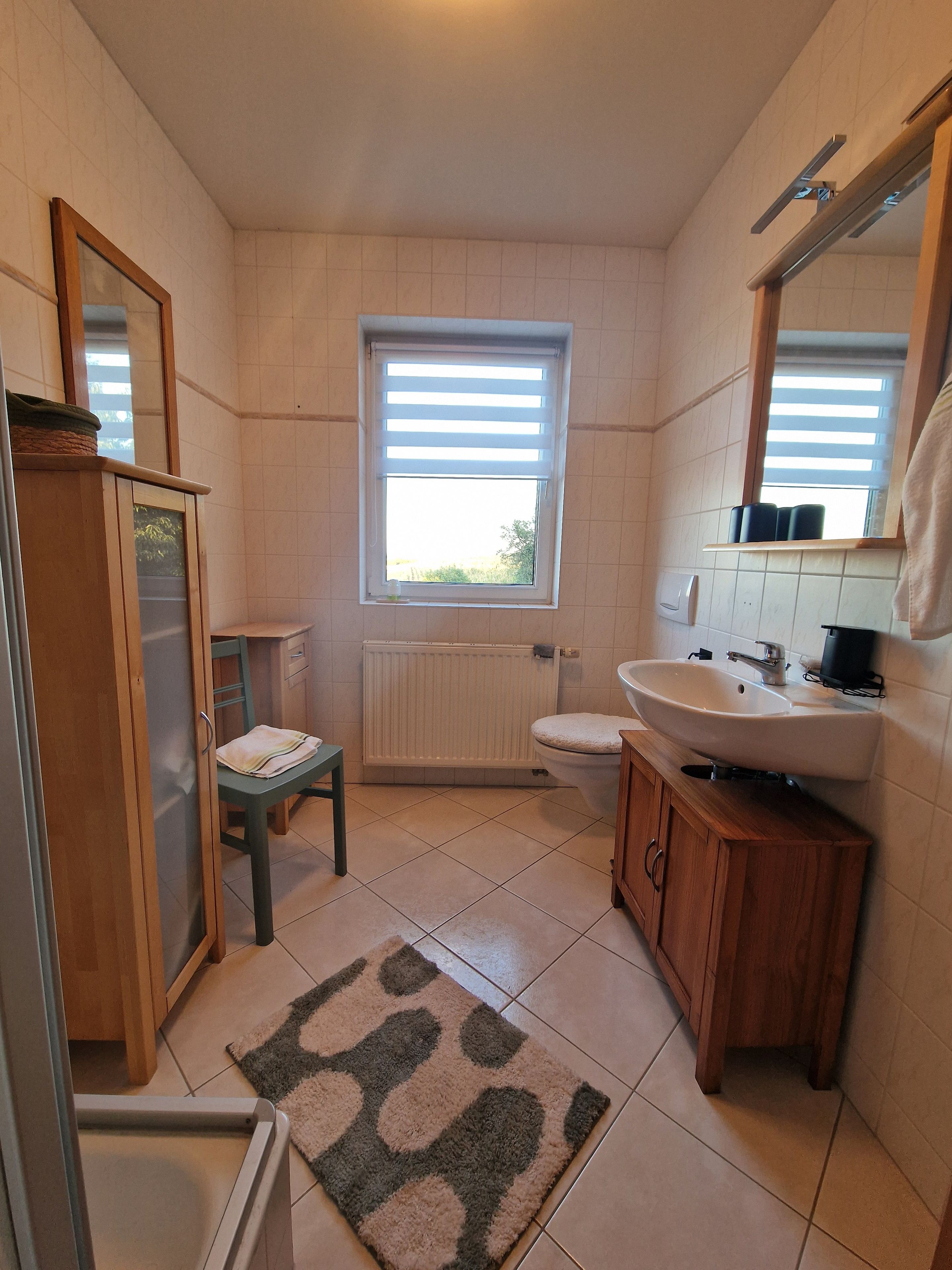 Ein Badezimmer mit Toilette, Waschbecken und Fenster.