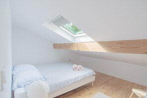 A small, single-bed room with a skylight, wooden beams, and a view of greenery outside. - Villa Campbell - entre Biarritz et Bayonne (Anglet)