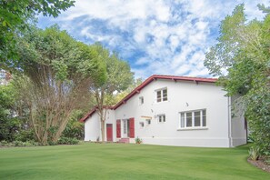 A two-story white building with a red roof, surrounded by lush greenery and trees. - Villa Campbell - entre Biarritz et Bayonne (Anglet)