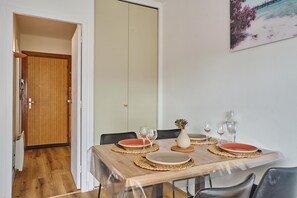A dining area with a wooden table set for four, including plates, glasses, and a vase with dried flowers. - L'écrin d'Arcachon - proche des plages (Arcachon)